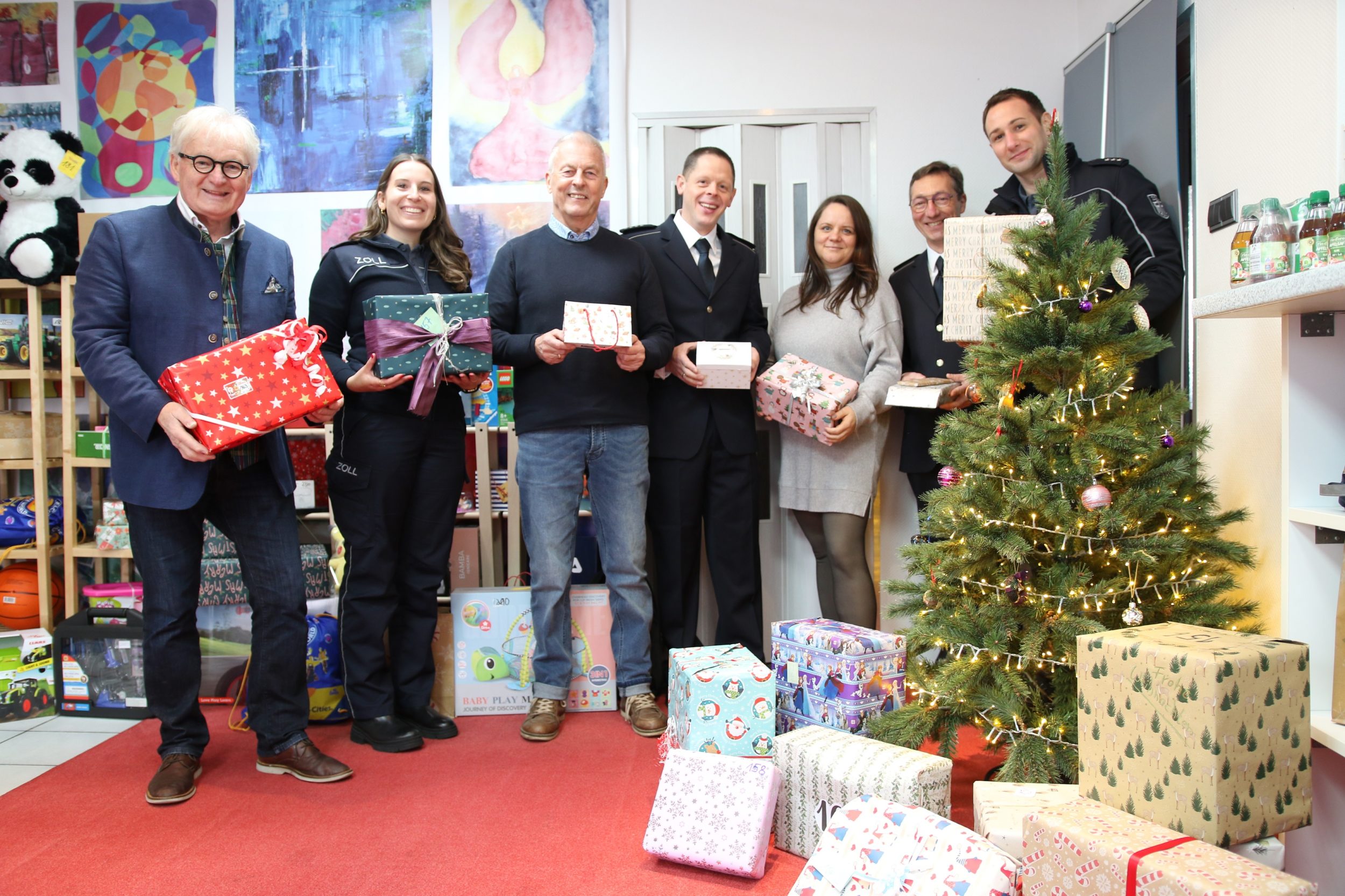 Unser Bild mit allen Personen im Weihnachtshaus zeigt von links: Kindertafel-Vorsitzender Stefan Labus mit seinem Vorstandkollegen Rainer Zink (Dritter von links), dazwischen und rechts daneben jeweils vom Hauptzollamt Schweinfurt Anna-Lena Gernert, Julian Mauchel, Stephanie Volk, Stefan Schramm und Benedikt Danz. Foto: Michael Horling